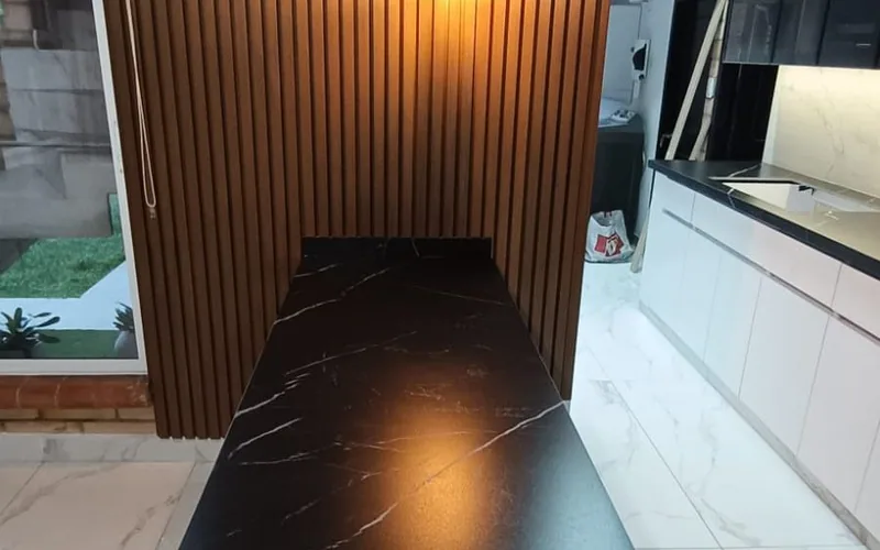 Barra revestida en Negro Marquina con detalle de listones de madera